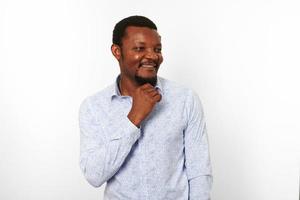 Happy african american black man in casual bright shirt brings hand to his small beard, isolated photo