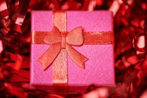 Red gift box in festive tinsel photo