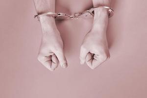 Hands in handcuffs, copy space. photo