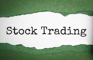 stock trading on torn paper and green background photo