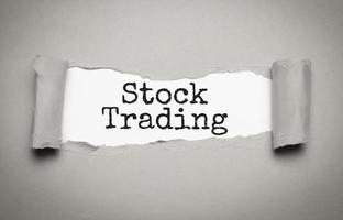 stock trading on torn paper and grey background photo