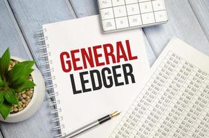 GENERAL LEDGER text written on white notebook with calculator and pen photo