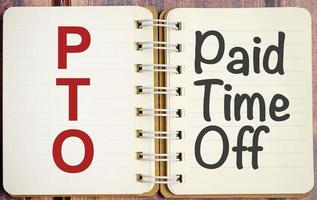 pto words on paper notebook and wooden background photo