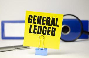 word GENERAL LEDGER on yellow sticker and blue folder photo