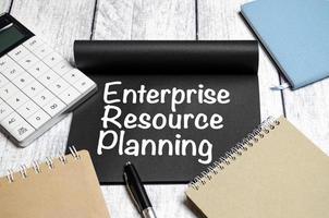 erp - enterprise resource planning words on notebook with calculator and notepads photo