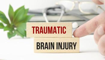wooden blocks text TRAUMATIC BRAIN INJURY, on a table with a stethoscope photo