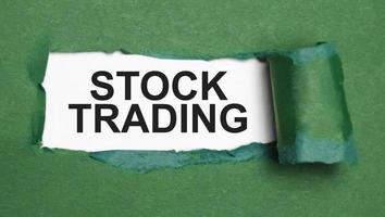 stock trading on torn paper and green background photo