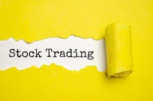 stock trading on torn paper and yellow background photo