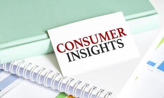 card with text Consumer insights on charts and notepads photo