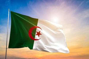 Algeria national flag waving in beautiful clouds. photo