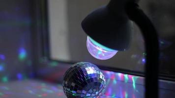 lampa lyser på disko boll. skön ljus i rum. interiör detaljer. roterande mekanism med bakgrundsbelysning. lampa är spinning. video