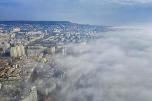 Fog clouds coming over the city from sea, aerial landscape from a drone. View from above. photo