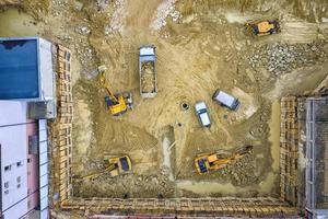 equipo pesado de construcción trabajando en el sitio de construcción. vista aerea desde dron foto