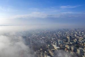 Fog clouds coming over the city from sea, aerial landscape from a drone. View from above. photo