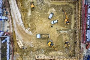 equipo pesado de construcción trabajando en el sitio de construcción. vista aerea desde dron foto