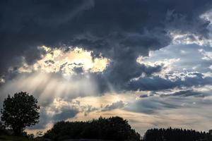 vista asombrosa de los rayos del sol entre las nubes tormentosas. vista de arte foto