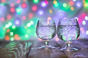 two glasses of champagne against bokeh lights background photo