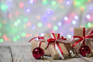 Christmas gift box with balls against bokeh background. Holiday greeting card photo