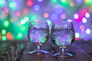 two glasses of champagne against bokeh lights background photo