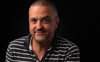 Man with one eyebrow raised on a black background with copy space photo