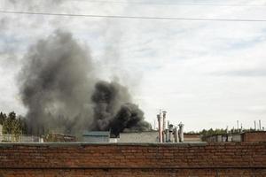 Burning of building. Smoke over buildings. Smoke in sky. photo