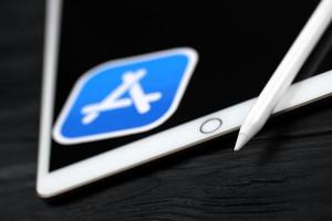 ternopil, ucrania - 8 de mayo de 2022 nuevo ipad de apple y lápiz de apple y logotipo azul de la tienda de aplicaciones sobre fondo negro. Apple Inc. es una empresa de tecnología americana foto