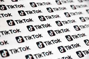 ternopil, ucrania - 8 de mayo de 2022 muchos logotipos de tiktok impresos en papel. tiktok o douyin es un famoso servicio chino de alojamiento de videos de formato corto propiedad de bytedance foto