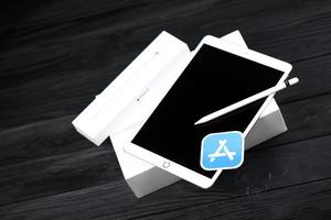 Ternopil, Ukraine - May 8, 2022 Brand new Apple iPad and Apple Pencil and blue app store logo on black background. Apple Inc. is an American technology company photo