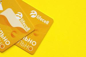 Ternopil, Ukraine - April 24, 2022 Lifecell new sim card with free contract on yellow background. Lifecell is ukrainian mobile telephone network operator and provider of wireless connection photo