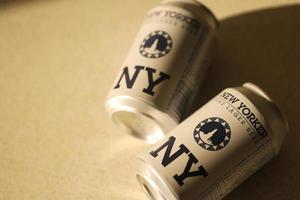 TERNOPIL, UKRAINE - JULY 18, 2022 Two cans of New Yorker fine lager beer with original logo and design on brown retro background photo