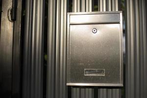 Mailbox on fence. Steel mailbox with lock. Fence details. photo