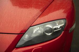 Headlight of red car. Transport details. photo