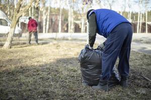 Garbage collection in bag. People clean up yard. photo