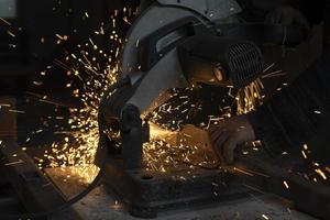 Sparks in dark. Cutting steel. Industrial equipment. photo