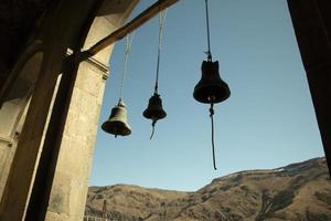 Bells against sky and mountains. Ropes for ringing. Bluebells of ancient world. photo