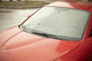 Red car. Wet car in parking lot. photo