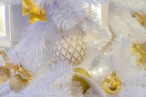 close up of christmas tree decorated with sparkling balls and garland with lights on. Festive background with copy space for your projects photo