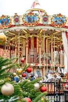 Moscow, Russia, 2021 - Christmas decorated tree and Colorful carousel in Manezhnaya Square in a snowy day. photo