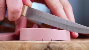 cut boiled sausage on a wooden board photo