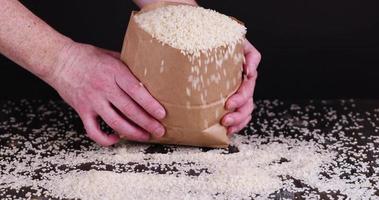 white rice in a bag is poured out on the table photo