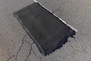 The repaired part of an asphalt road with patches photo