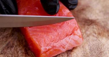 cutting red salted salmon into pieces during cooking photo