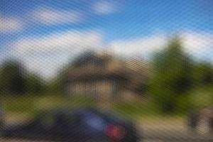 Blurry shot of street through grid. Mesh texture. photo