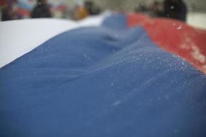 Flag of Russia in winter. Large cloth made of fabric. Symbol of state power in Russian Federation. photo