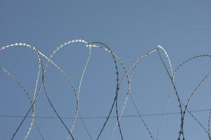 Barbed wire on fence. Fencing of industrial zone. Safety from thieves. photo