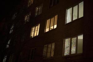 Windows in night city. Light of windows in house. Residential apartments in dark. photo