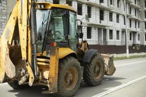 Yellow tractor, Construction machinery in city. Heavy vehicles with big wheels. photo