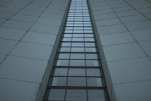 High-rise building on gray day. Architecture details. Surface of wall. photo