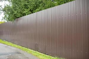 Brown fence made of metal. Fence made of profile sheet. photo