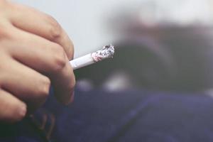 close up smoking Cigarettes in hand Smoke spread with a soft-focus. photo